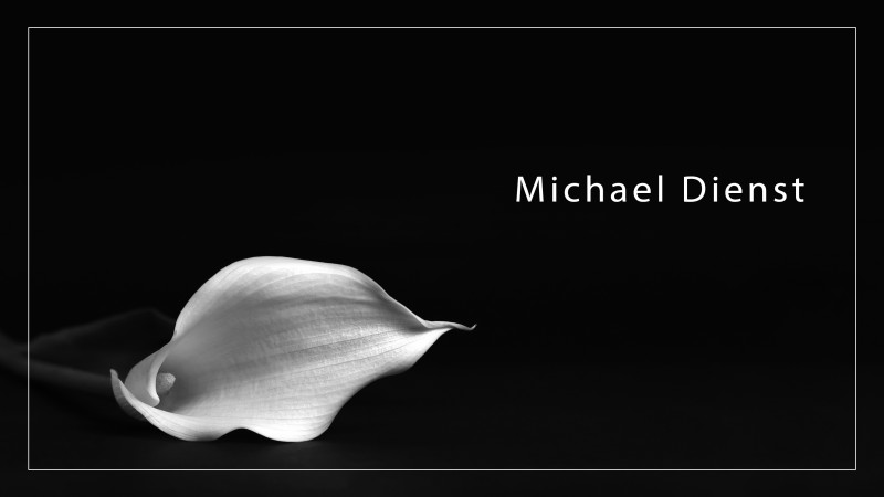 Blume auf schwarzem Hintergrund mit Text Michael Dienst